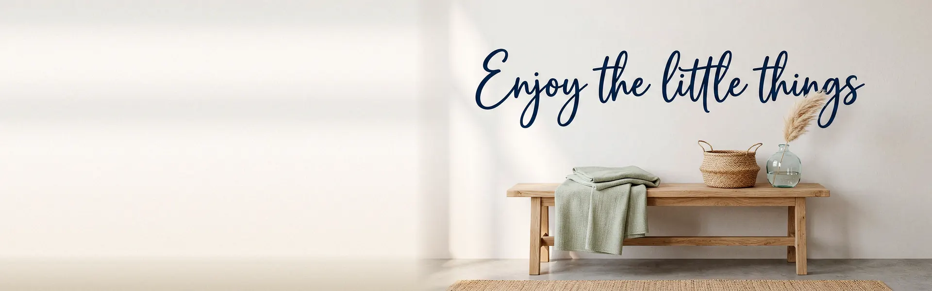 Phrase « Enjoy the little things » en lettrage adhésif bleu marine au-dessus d'un banc en bois